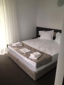 a bedroom with a bed with two towels on it at IOANA - camere de inchiriat in Mangalia