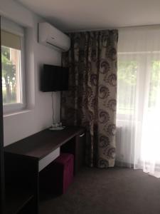 a hotel room with a desk and a window at IOANA - camere de inchiriat in Mangalia