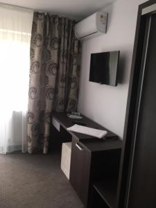 a hotel room with a desk and a television at IOANA - camere de inchiriat in Mangalia