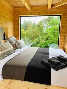 Le Lodge Mimitsu في Hyuga: غرفة نوم بسريرين مع نافذة كبيرة