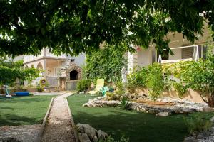 a house with a yard with green grass at Apartments Vodice Olga Matic in Vodice