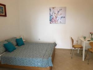 um quarto com uma cama, uma mesa e uma fotografia em Studio apartment Milla em Rijeka