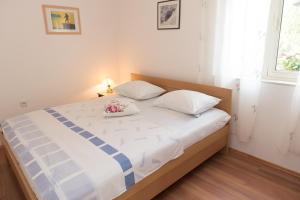 a bedroom with a bed with white sheets and flowers on it at Apartments Vodice Olga Matic in Vodice