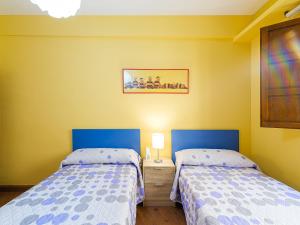 two beds in a room with yellow walls at Apartamento San Vicente by Toledo AP in Toledo