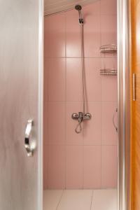 y baño con ducha de azulejos rosados. en OLYMPIC HOTELS Belek, en Belek