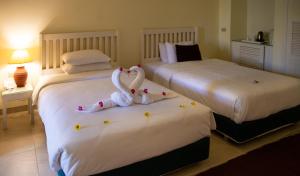 two swans sitting on two beds in a hotel room at Caesar Bay Resort in Marsa Matruh