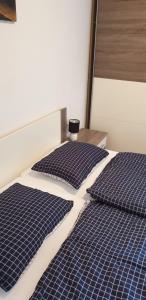 two beds with blue and white sheets and pillows at Stole Apartment in Izola