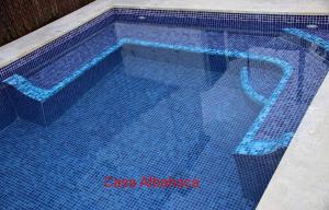 a swimming pool with blue tiles on the floor at Casa Rural Albahaca in Jimera de Líbar