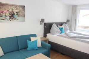 salon z niebieską kanapą i oknem w obiekcie Apartment Elisa w Kaprunie