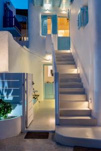 a staircase in a house with blue doors at Mykonian Mews Luxury Suites in Psarou