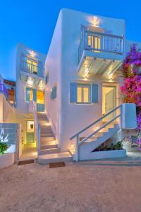 a white house with stairs in front of it at Mykonian Mews Luxury Suites in Psarou