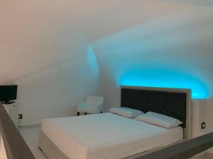 a bedroom with a bed with a blue light on it at Little Dreams Apartment in Trani