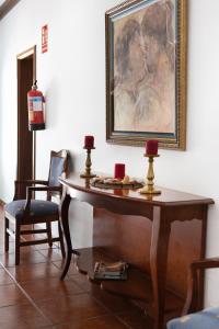 a table in a room with a painting and a chair at B&B Hotelito el Campo in Yaiza