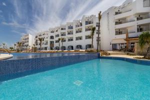 a large swimming pool in front of a building at Zahara Beach & Spa by QHotels - Adults Recommended in Zahara de los Atunes