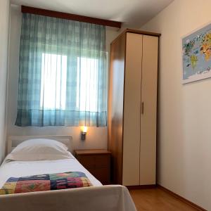 a bedroom with a bed and a window at Apartment Excellent in Nečujam