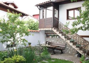een tuin met een bank en een huis bij Grancharova Guest House in Bansko