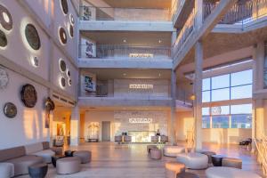 a large lobby with white chairs and tables in a building at Zahara Beach & Spa by QHotels - Adults Recommended in Zahara de los Atunes