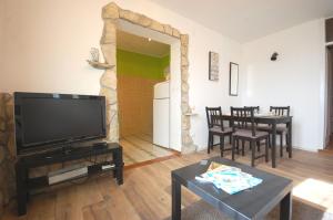a living room with a flat screen tv and a table at Apartment Iskra in Njivice