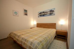 1 dormitorio con 1 cama y 2 luces en 2 mesas en Apartment Weisshorn en Crans-Montana