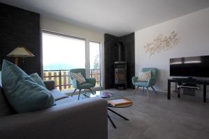 sala de estar con sofá, sillas y TV en Apartment Weisshorn en Crans-Montana