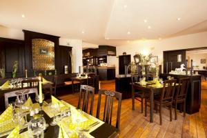 a dining room with tables and chairs and a kitchen at Hotel Weißes Roß in Elsterwerda