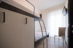 a bedroom with a bunk bed and a ladder at Hotel Bristol in Caorle