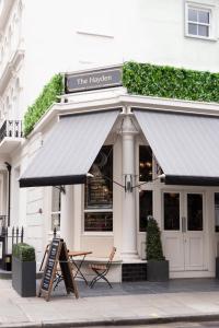 un restaurante con una señal frente a un edificio en The Hayden Pub & Rooms en Londres