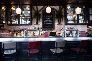 a bar with three stools in front of a counter at The Hayden Pub & Rooms in London