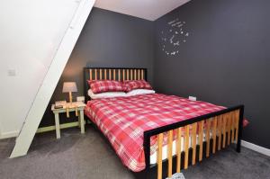 a bedroom with a bed and a black wall at Tigh Na Claddoch in Dunoon