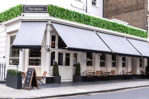a restaurant with tables and chairs in front of a building at The Hayden Pub & Rooms in London