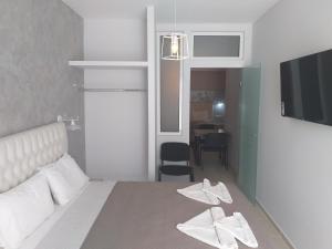 um quarto com uma cama com toalhas brancas em Labyrinth Hotel em Georgioupolis