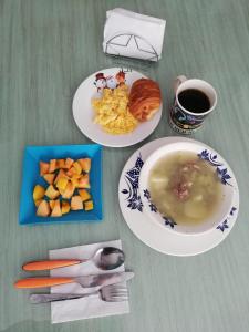 una mesa con dos platos de comida y un tazón de sopa en Habitación con baño privado, en Tunja