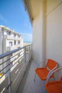 a balcony with two chairs and a view of the ocean at Hotel Continental in Caorle