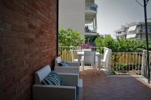 a patio with chairs and tables and a brick wall at Sogno Mediterraneo in Formia