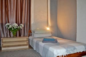 a small bedroom with a bed and a vase of flowers at Capsule Hotel Tolmachevo in Ob