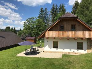 a house with a deck and a table in a yard at Chalupa Pecivál Lipno in Lipno nad Vltavou
