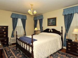 a bedroom with a large bed with blue curtains at Second Street Suite in Clearfield