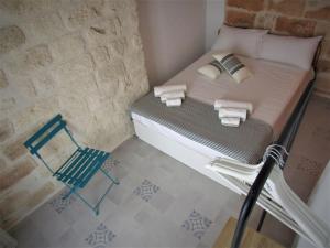 een kleine slaapkamer met een bed en een stoel bij Nisea in Polignano a Mare