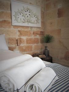 een slaapkamer met een bed met witte handdoeken bij Nisea in Polignano a Mare