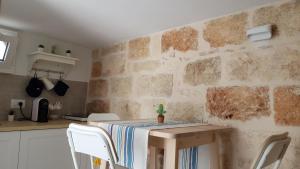 a table and chairs in a kitchen with a stone wall at Nisea in Polignano a Mare