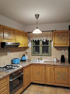 una cocina con armarios de madera y fregadero en Drumul Poienii Apartment, en Brasov