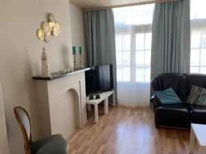 uma sala de estar com lareira e televisão em Vakantiehuis Babelle 2 em Blankenberge