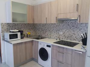 a kitchen with a washing machine and a microwave at Casa Dorotea in Playa del Cura