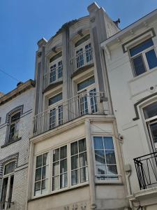 um grande edifício branco com janelas e uma varanda em Vakantiehuis Babelle 2 em Blankenberge