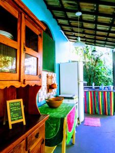 a kitchen with a green table and a refrigerator at Chale Kangaroos Imbassai in Imbassai