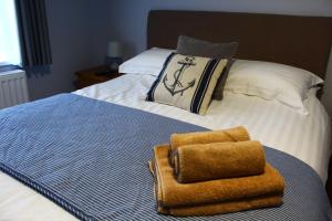 Una cama con dos toallas encima. en Pinewood B&B, en Saundersfoot