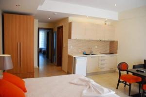 a room with a kitchen with a bed and a table at LESSIOTI APARTMENTS in Methana