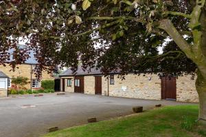 een gebouw met een parkeerplaats naast een boom bij Church Farm Lodge in Harrington