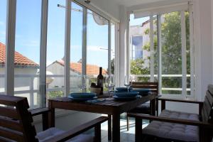 a dining room with a table and some windows at Lovely studio apartment Mare e Sole in Labin
