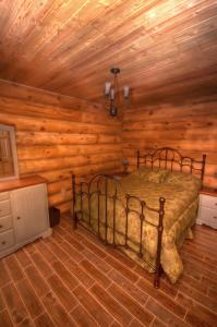 1 dormitorio con 1 cama en una cabaña de madera en Le Chalet Le Bois Rond Des Ruisseaux, en Saint-Tite-des-Caps